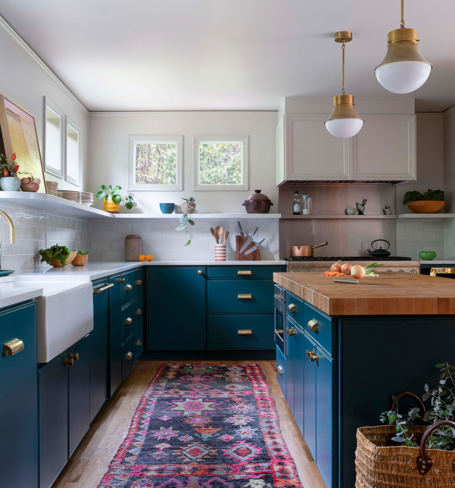 Design ideas for a mid-sized midcentury eat-in kitchen in Portland with a farmhouse sink, beaded inset cabinets, blue cabinets, quartzite benchtops, green splashback, ceramic splashback, stainless steel appliances, light hardwood floors, with island, beige floor and white benchtop.