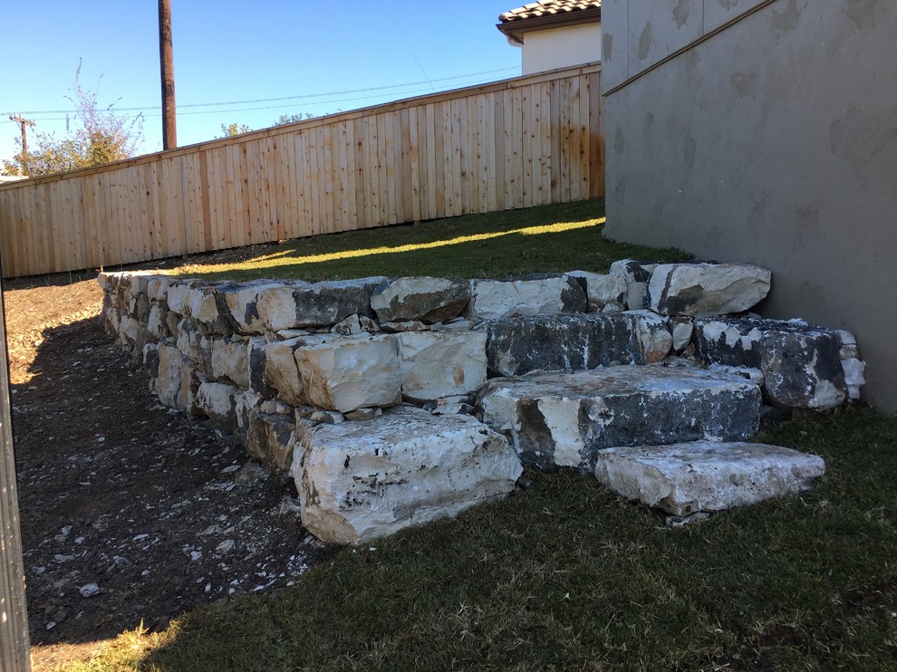 Design ideas for a small rustic stone retaining wall landscape.