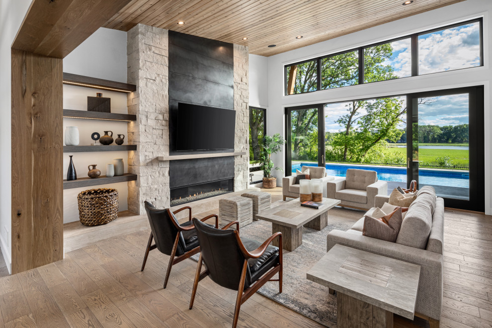 Design ideas for an expansive contemporary open plan living room in Minneapolis with a stone fireplace surround, white walls, light hardwood flooring, a ribbon fireplace, a wall mounted tv, beige floors and a wood ceiling.