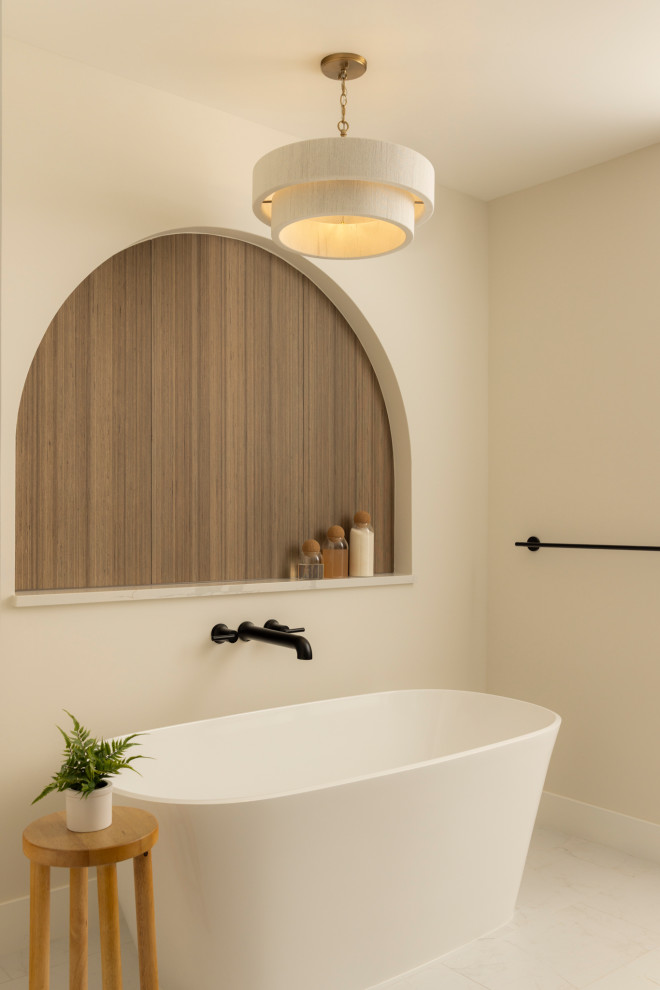 Trendy white floor freestanding bathtub photo in Denver with beige walls