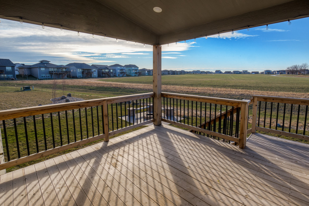 Transitional backyard deck photo with a roof extension