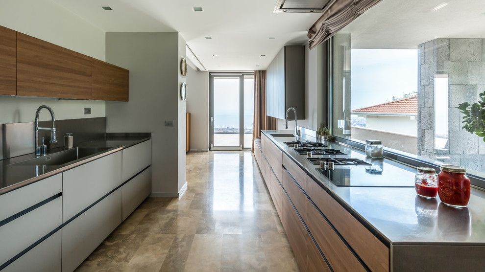 Inspiration for a contemporary galley kitchen in Other with an integrated sink, flat-panel cabinets, grey cabinets, stainless steel benchtops, window splashback, no island and beige floor.