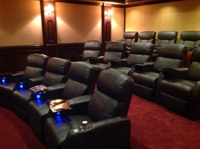 This is an example of a traditional home theatre in Miami with a projector screen.