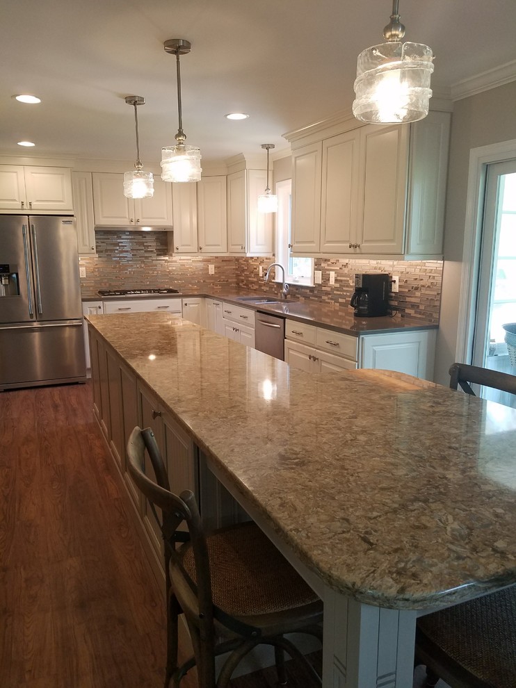 Mid-sized transitional l-shaped dark wood floor open concept kitchen photo in Baltimore with an undermount sink, raised-panel cabinets, white cabinets, granite countertops, metallic backsplash, matchstick tile backsplash, stainless steel appliances and an island