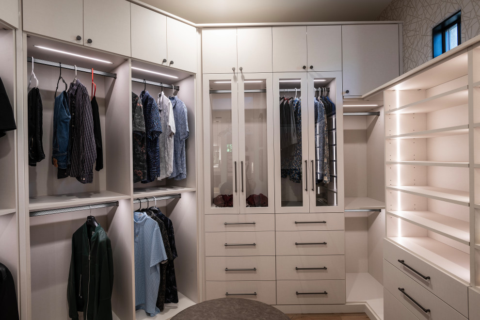 Walk-in closet - large contemporary men's medium tone wood floor and brown floor walk-in closet idea in Phoenix with glass-front cabinets and white cabinets