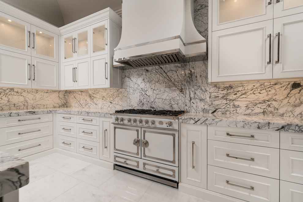 This is an example of an expansive transitional u-shaped separate kitchen in Phoenix with a farmhouse sink, recessed-panel cabinets, white cabinets, marble benchtops, multi-coloured splashback, marble splashback, stainless steel appliances, marble floors, multiple islands, white floor and green benchtop.