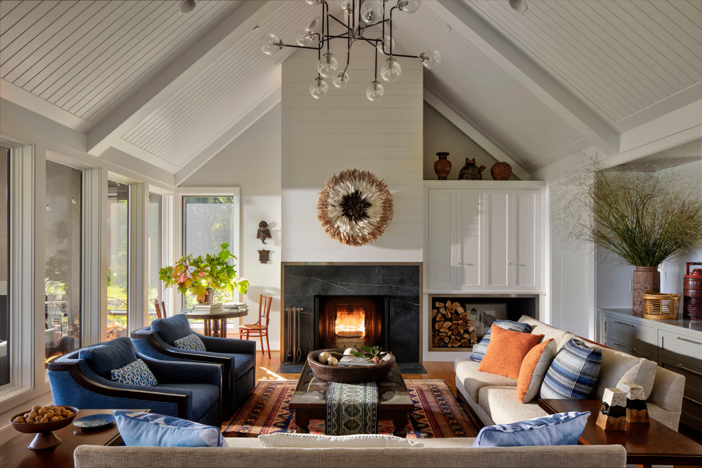 Inspiration for a large beach style family room in Baltimore with white walls, light hardwood floors, a standard fireplace, a built-in media wall, brown floor and exposed beam.