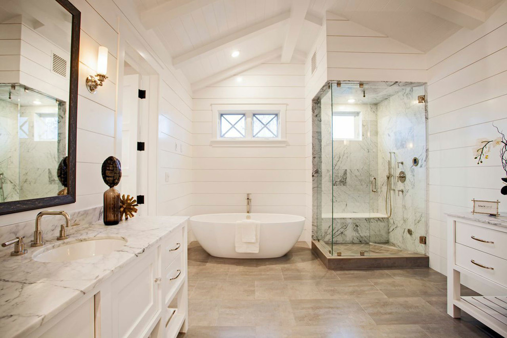 This is an example of a country bathroom in Orange County with white cabinets, a freestanding tub, a corner shower, white tile, white walls and recessed-panel cabinets.