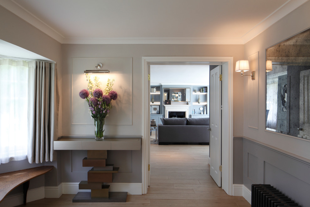 Mid-sized contemporary hallway in London with light hardwood floors and grey walls.