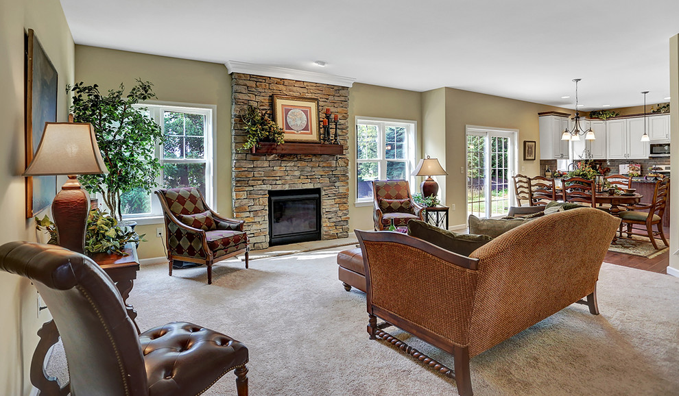 Inspiration for a large arts and crafts open concept family room in Philadelphia with carpet, a standard fireplace, a stone fireplace surround, no tv, beige walls and beige floor.