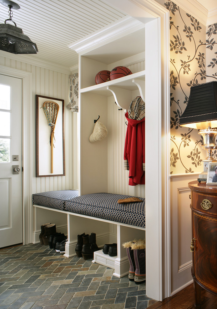 This is an example of a traditional mudroom in New York with brick floors and grey floor.