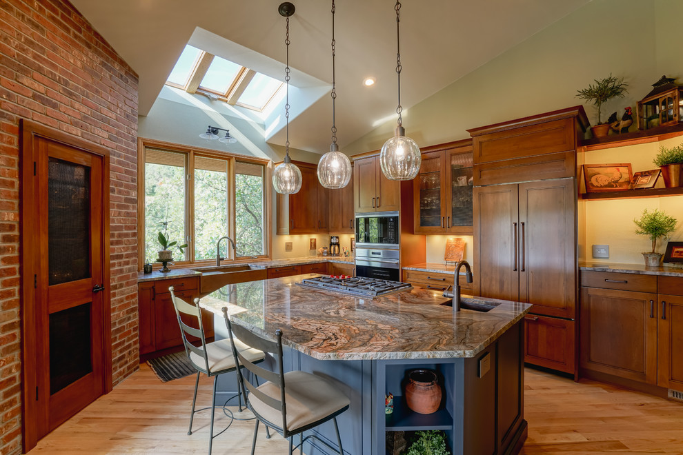 Inspiration for a mid-sized transitional medium tone wood floor and brown floor kitchen remodel in Denver with a farmhouse sink, recessed-panel cabinets, medium tone wood cabinets, granite countertops, paneled appliances and an island