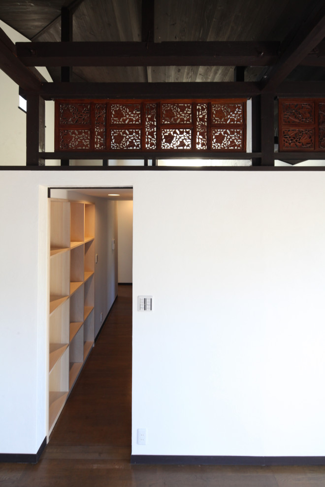 Ispirazione per una camera da letto stile loft etnica di medie dimensioni con pareti bianche, pavimento in legno massello medio, pavimento marrone e soffitto in legno