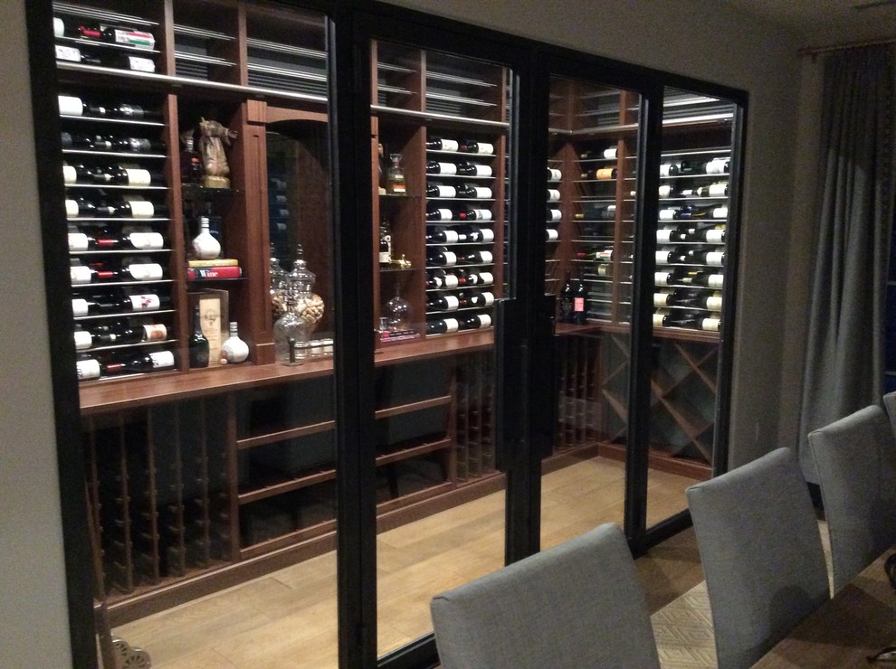 Photo of a small contemporary wine cellar in Orange County with storage racks and light hardwood floors.