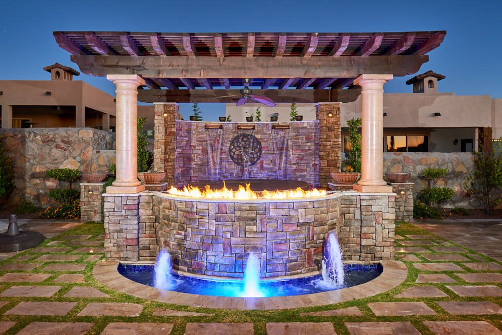 This is an example of a mediterranean backyard patio in Other with a fire feature, a pergola and natural stone pavers.