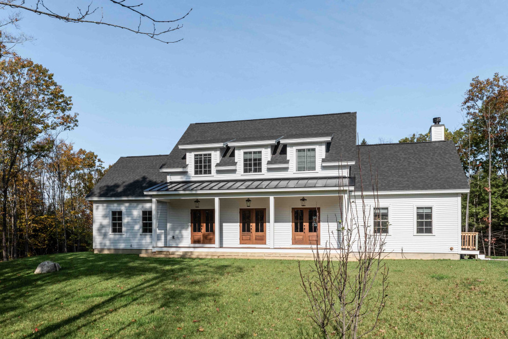 Foto de fachada de casa blanca y negra clásica de tamaño medio de dos plantas con revestimiento de vinilo, tejado a dos aguas, tejado de teja de madera y tablilla