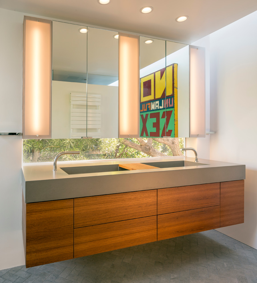Design ideas for a mid-sized modern master bathroom in San Francisco with an integrated sink, flat-panel cabinets, medium wood cabinets, concrete benchtops, a wall-mount toilet, gray tile, porcelain tile, white walls and porcelain floors.