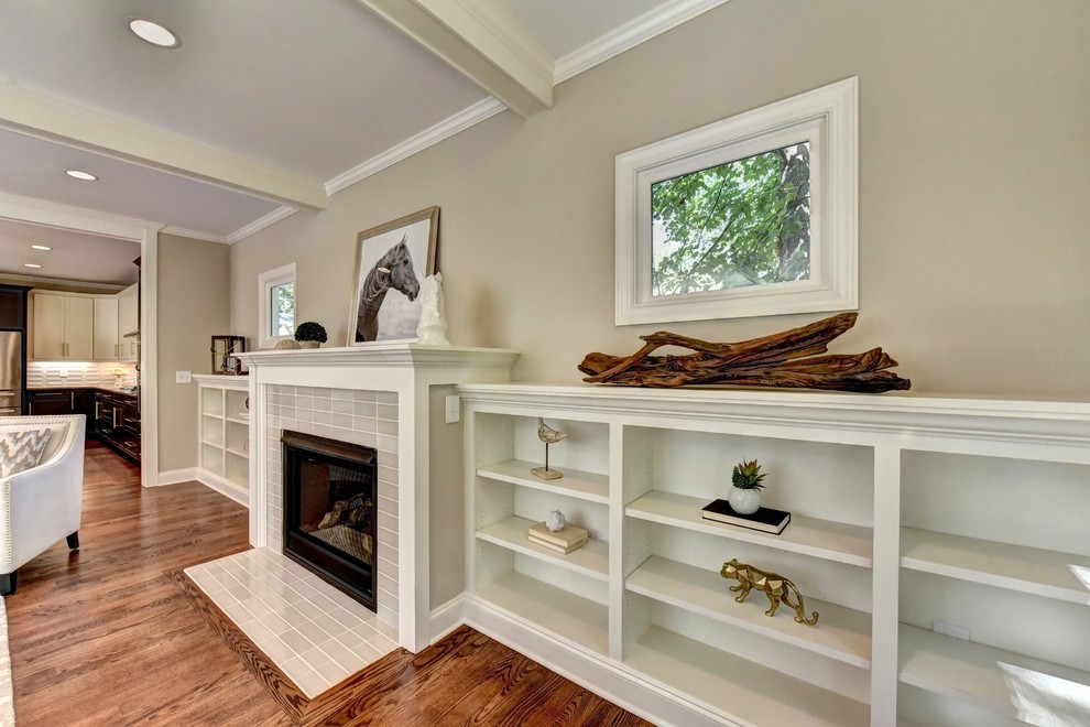 Photo of an arts and crafts open concept family room in Atlanta with beige walls, medium hardwood floors, a standard fireplace, a tile fireplace surround and a wall-mounted tv.