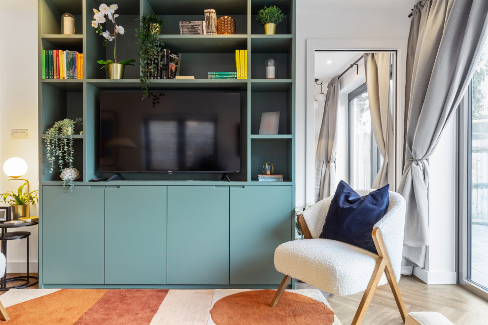 Kleines Modernes Wohnzimmer mit weißer Wandfarbe, braunem Holzboden und Multimediawand in London