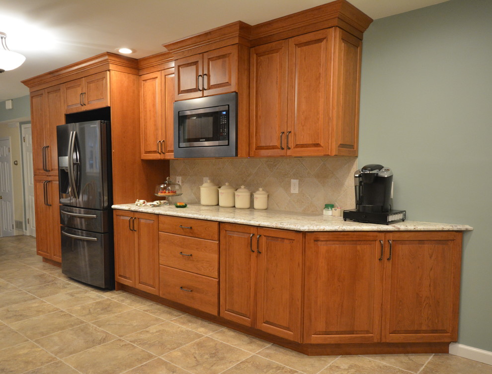 This is an example of a large traditional galley kitchen in Philadelphia with raised-panel cabinets, medium wood cabinets, quartz benchtops and no island.
