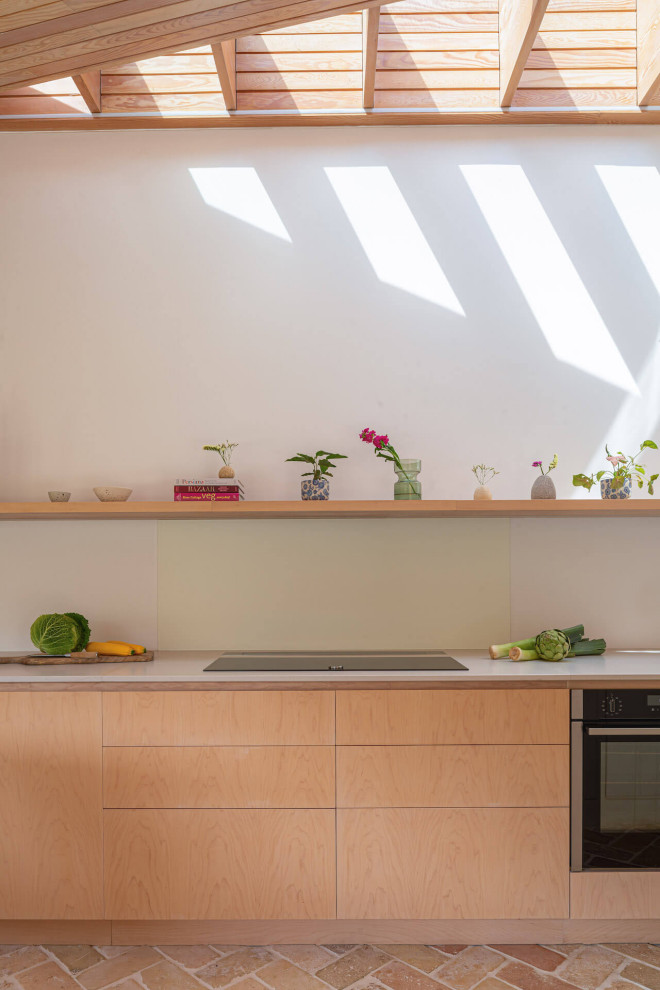 Foto på ett stort skandinaviskt grå linjärt kök med öppen planlösning, med släta luckor, skåp i ljust trä, bänkskiva i koppar, tegelgolv och en köksö