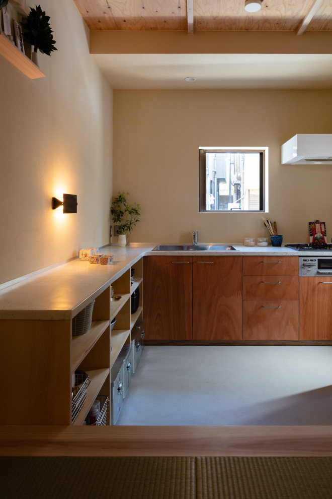 Immagine di una piccola cucina con nessun'anta, top alla veneziana, pavimento in cemento, pavimento grigio e top bianco