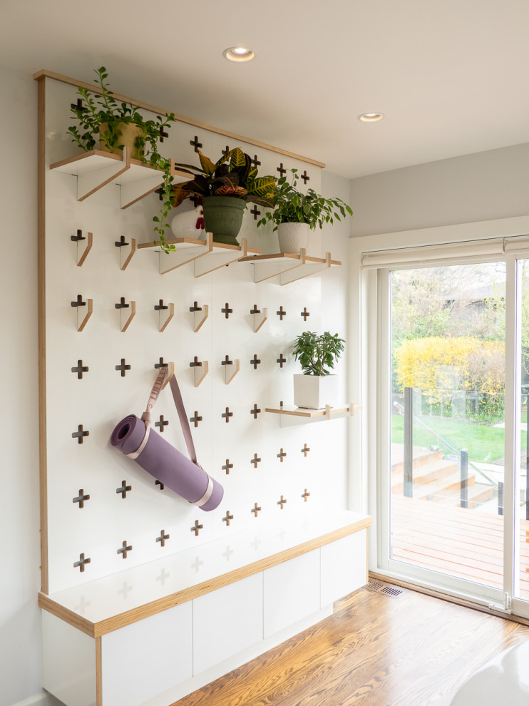 Inspiration for a small transitional light wood floor and brown floor hallway remodel in Vancouver with white walls