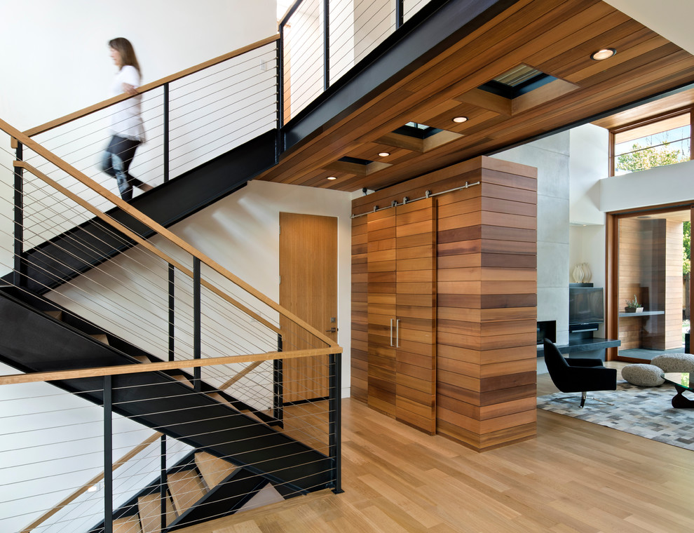 This is an example of a contemporary wood u-shaped staircase in San Francisco with cable railing.
