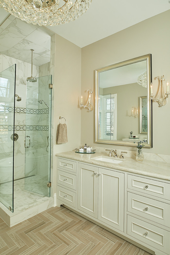 Design ideas for an expansive traditional master bathroom in Grand Rapids with recessed-panel cabinets, white cabinets, a freestanding tub, a corner shower, beige walls, an undermount sink, a hinged shower door and beige benchtops.