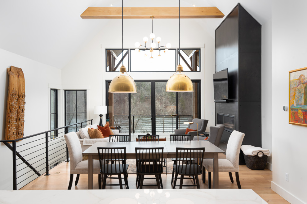 Mittelgroße Wohnküche mit weißer Wandfarbe, braunem Holzboden, Gaskamin, Kaminumrandung aus Beton und gewölbter Decke in Sonstige