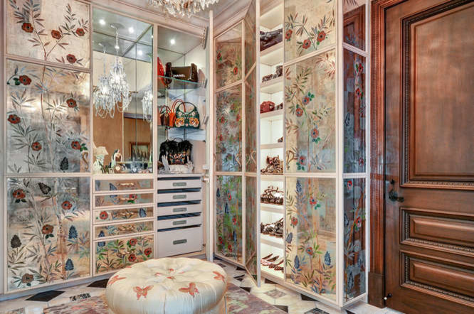Inspiration for an expansive mediterranean gender-neutral walk-in wardrobe in Tampa with glass-front cabinets, distressed cabinets, carpet and beige floor.