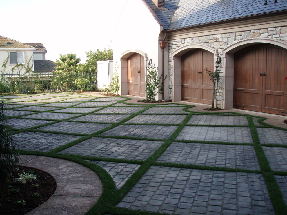 Mid-sized traditional front yard partial sun driveway in Los Angeles with natural stone pavers.