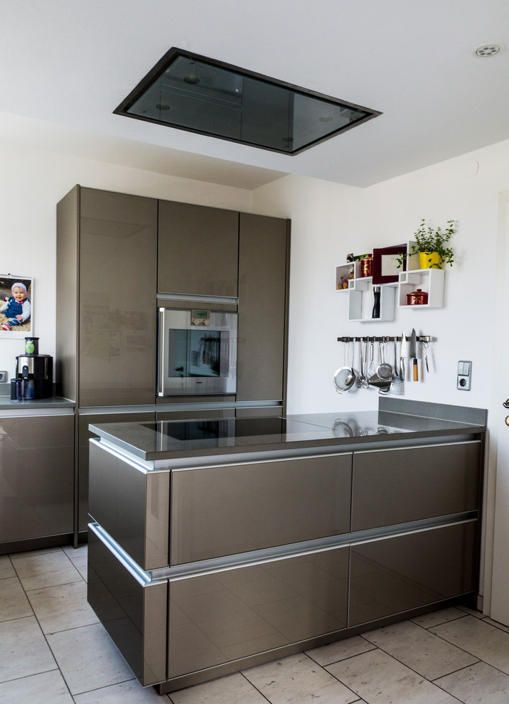 Küche mit Waschbecken, Glasfronten, grünen Schränken, Mineralwerkstoff-Arbeitsplatte, Küchengeräten aus Edelstahl und Marmorboden in Stuttgart