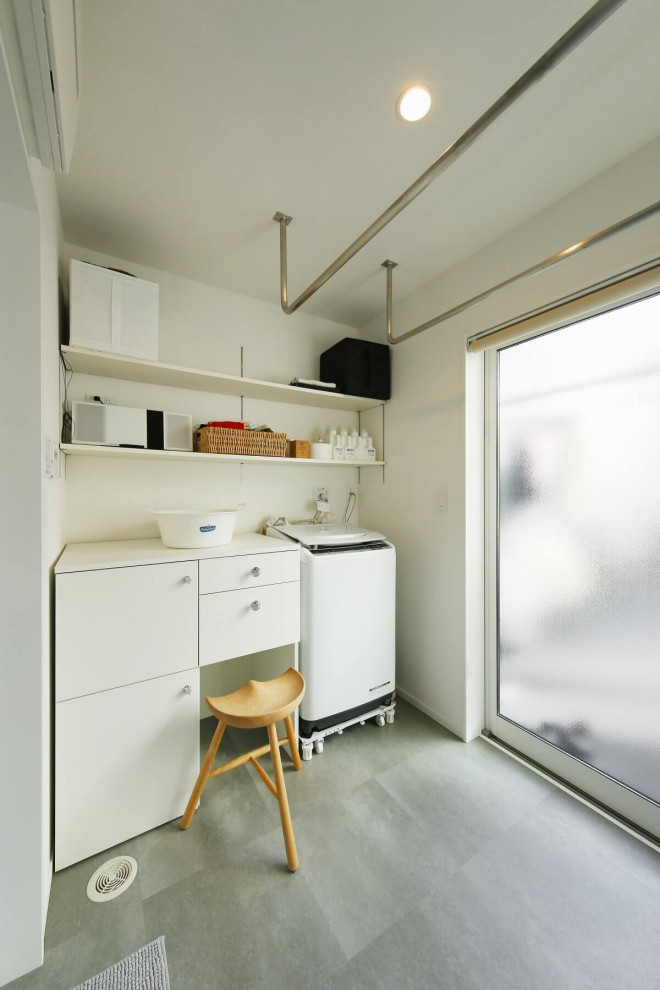Mid-sized industrial laundry room in Tokyo Suburbs with raised-panel cabinets, white cabinets, white walls, grey floor, wallpaper and wallpaper.