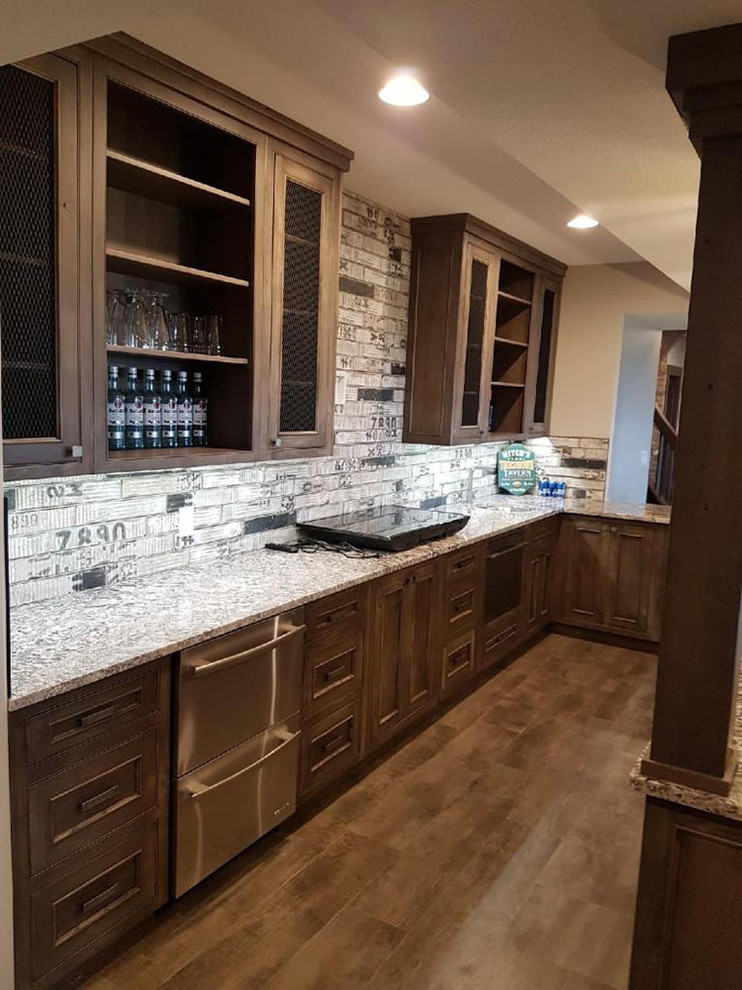 This is an example of a mid-sized traditional galley home bar in Calgary with beaded inset cabinets, dark wood cabinets, granite benchtops, multi-coloured splashback, dark hardwood floors, brown floor and grey benchtop.