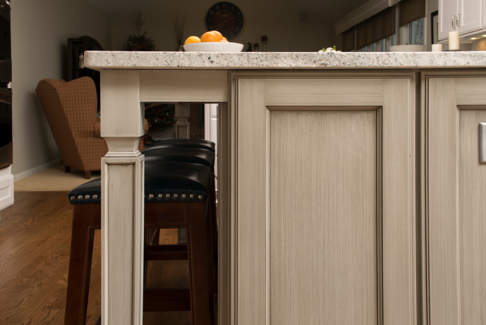 Large transitional l-shaped medium tone wood floor home design photo in Chicago with a single-bowl sink, recessed-panel cabinets, gray cabinets, granite countertops, gray backsplash, ceramic backsplash, stainless steel appliances and an island