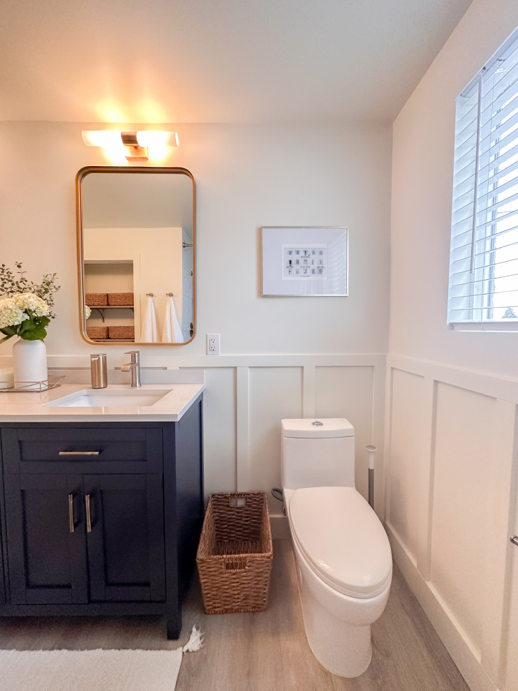 Источник вдохновения для домашнего уюта: ванная комната среднего размера в морском стиле с фасадами в стиле шейкер, синими фасадами, душем в нише, унитазом-моноблоком, керамической плиткой, белыми стенами, врезной раковиной, столешницей из искусственного кварца, бежевым полом, шторкой для ванной, белой столешницей, тумбой под две раковины, напольной тумбой, панелями на стенах, душевой кабиной и полом из винила
