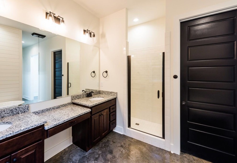 Design ideas for a large country master bathroom in Atlanta with raised-panel cabinets, dark wood cabinets, a claw-foot tub, an alcove shower, white tile, white walls, concrete floors, an undermount sink, granite benchtops, grey floor and a hinged shower door.