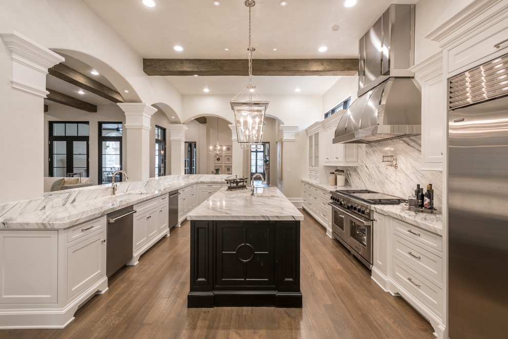 This is an example of an expansive traditional kitchen in Dallas with a single-bowl sink, recessed-panel cabinets, white cabinets, marble benchtops, white splashback, marble splashback, stainless steel appliances, medium hardwood floors and with island.