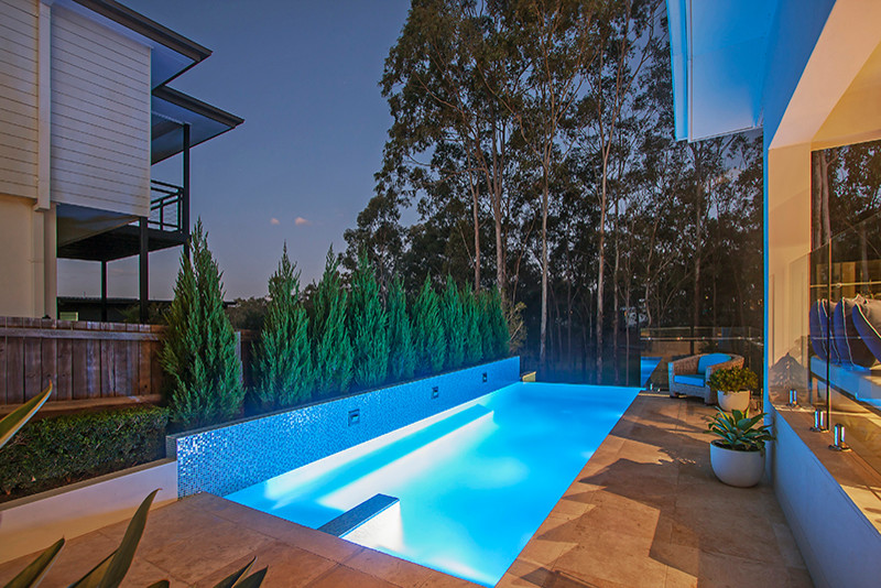 Photo of a mid-sized contemporary backyard rectangular aboveground pool in Brisbane with a water feature and tile.