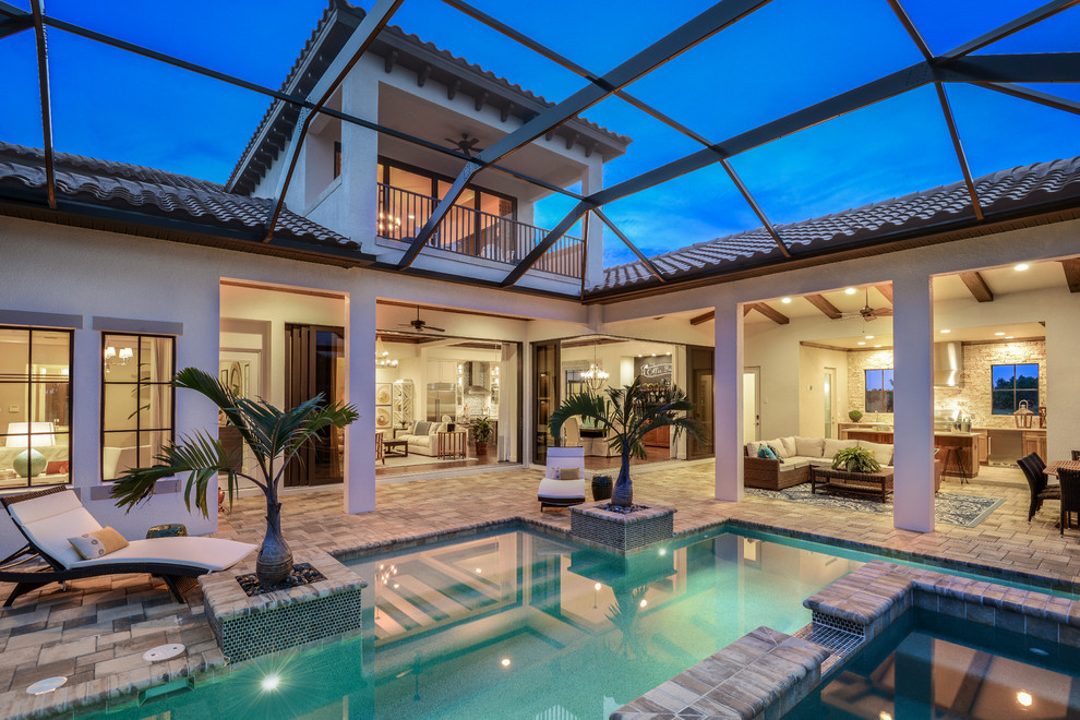 Inspiration for an expansive mediterranean two-storey beige exterior in Tampa with a gable roof.