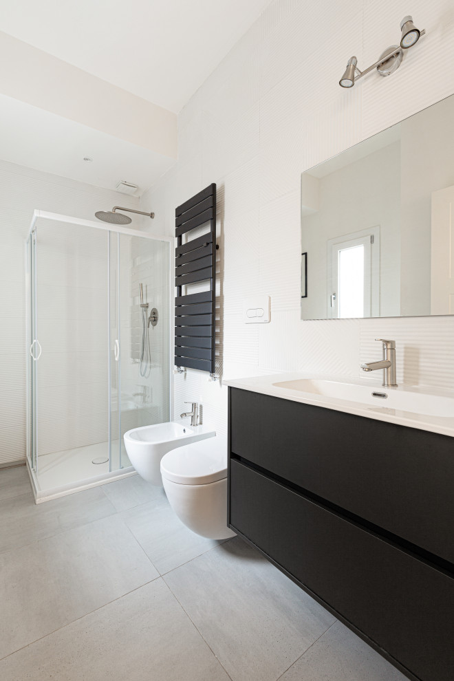 Inspiration for a mid-sized contemporary 3/4 bathroom in Milan with beaded inset cabinets, grey cabinets, a corner shower, a wall-mount toilet, white tile, ceramic tile, white walls, porcelain floors, a drop-in sink, grey floor, a sliding shower screen, white benchtops, a single vanity, a floating vanity and recessed.