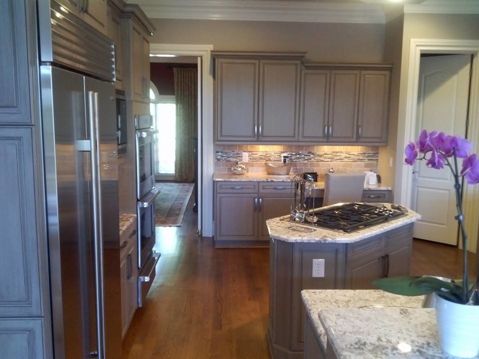 Inspiration for a mid-sized transitional l-shaped eat-in kitchen remodel with a single-bowl sink, raised-panel cabinets, gray cabinets, granite countertops, beige backsplash, glass tile backsplash and an island