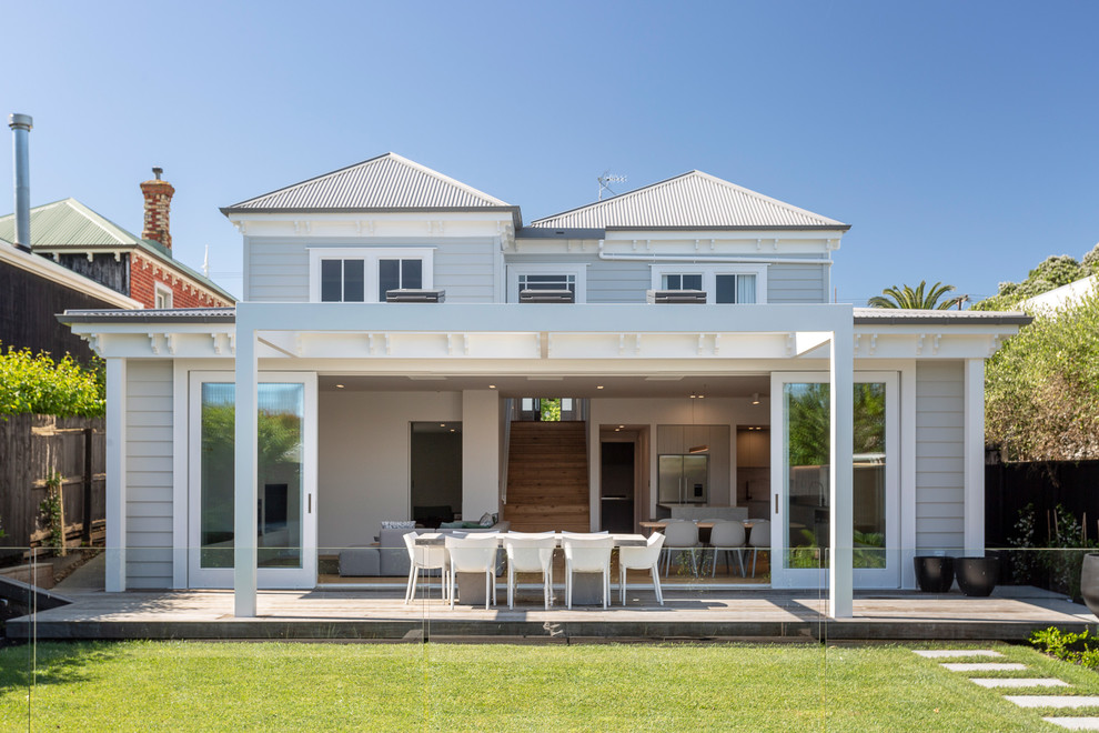 Large transitional backyard deck in Auckland with a pergola.