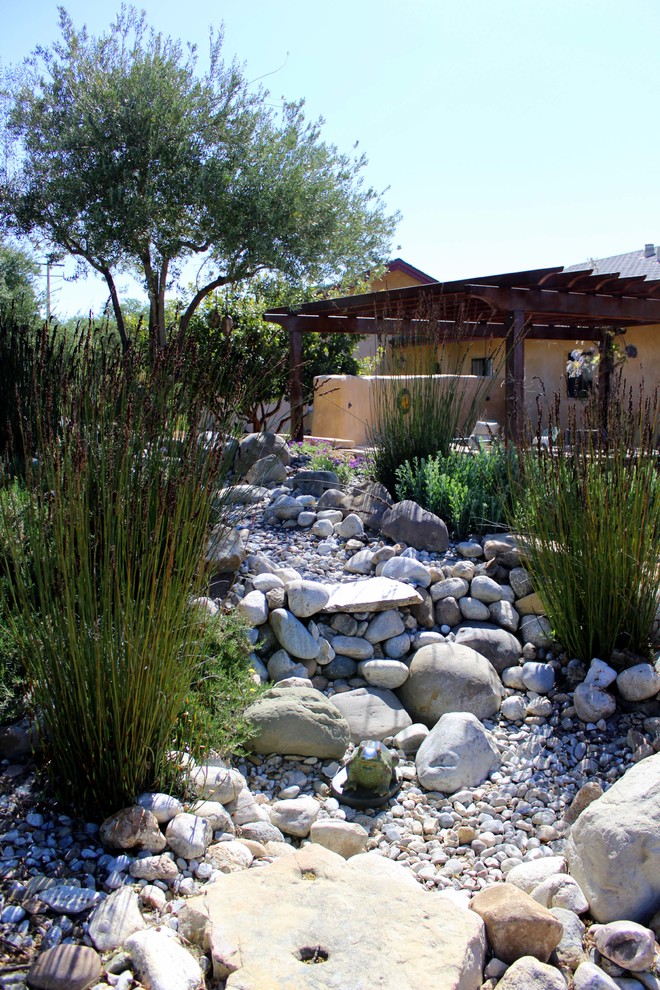 Photo of a mediterranean backyard garden in San Luis Obispo with a water feature.