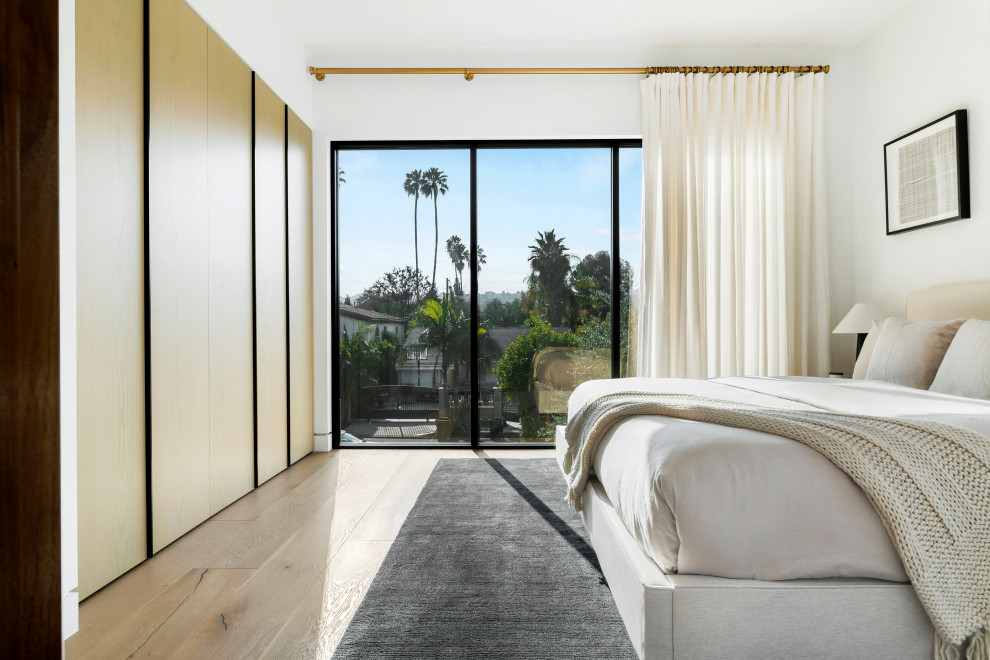 Mittelgroßes Modernes Gästezimmer mit weißer Wandfarbe, beigem Boden und hellem Holzboden in Los Angeles