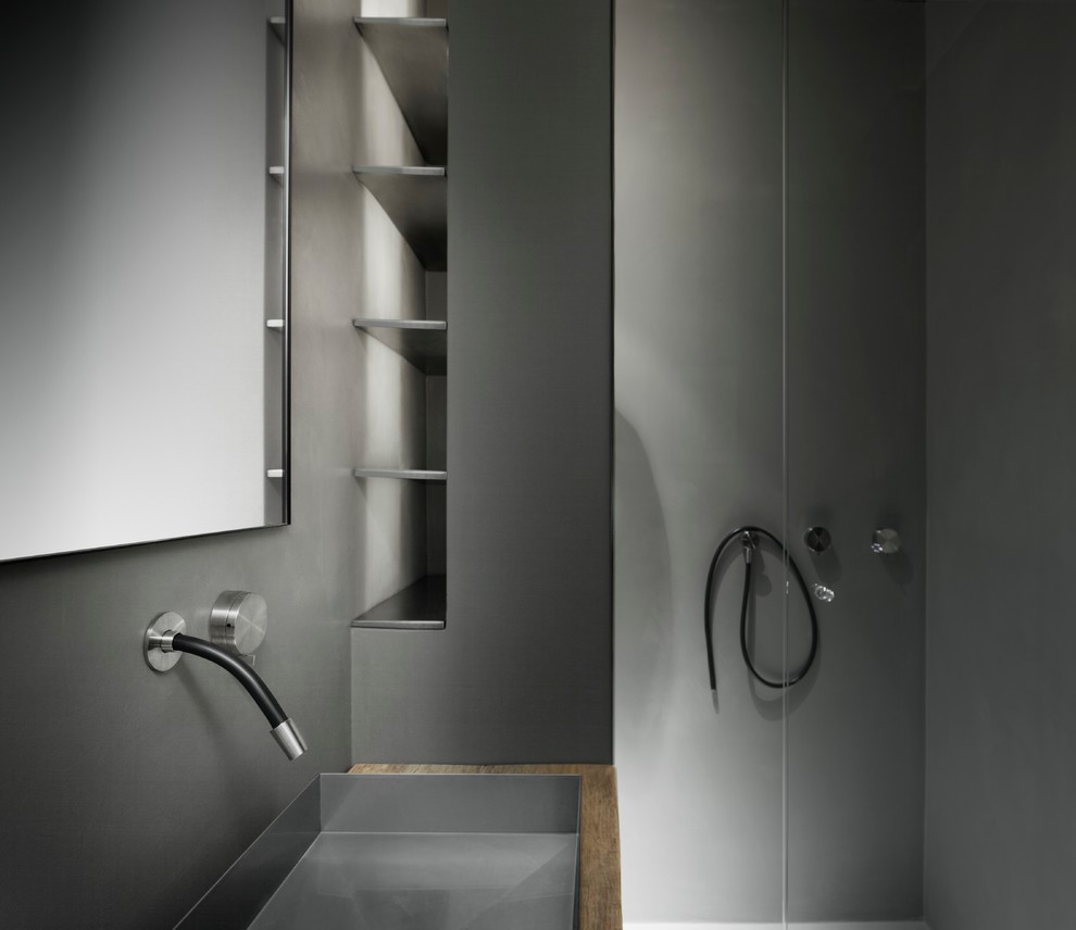 This is an example of a small contemporary 3/4 bathroom in Milan with open cabinets, a curbless shower, a bidet, grey walls, a trough sink and wood benchtops.