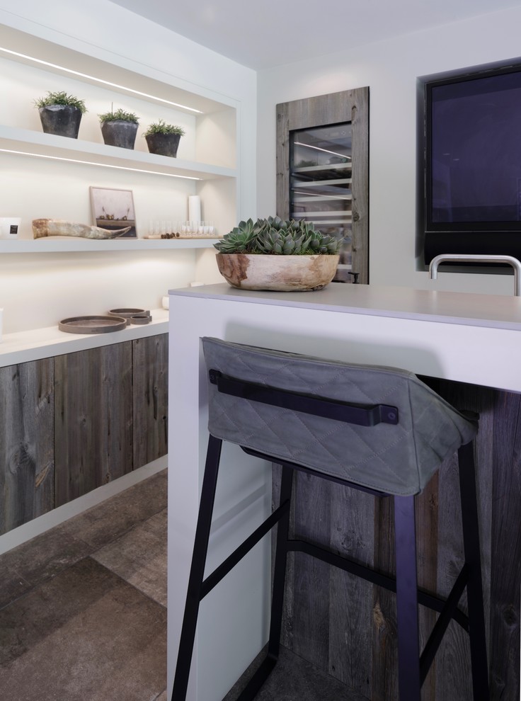 Inspiration for a mid-sized contemporary galley wet bar in Cheshire with a drop-in sink, flat-panel cabinets, medium wood cabinets, concrete benchtops, white splashback, ceramic splashback, ceramic floors and grey floor.