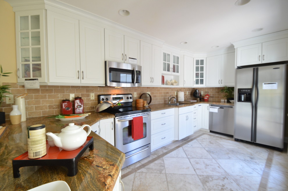 Photo of a traditional galley eat-in kitchen in San Francisco with a drop-in sink, raised-panel cabinets, white cabinets, granite benchtops, beige splashback, stainless steel appliances, a peninsula, ceramic splashback, ceramic floors and white floor.