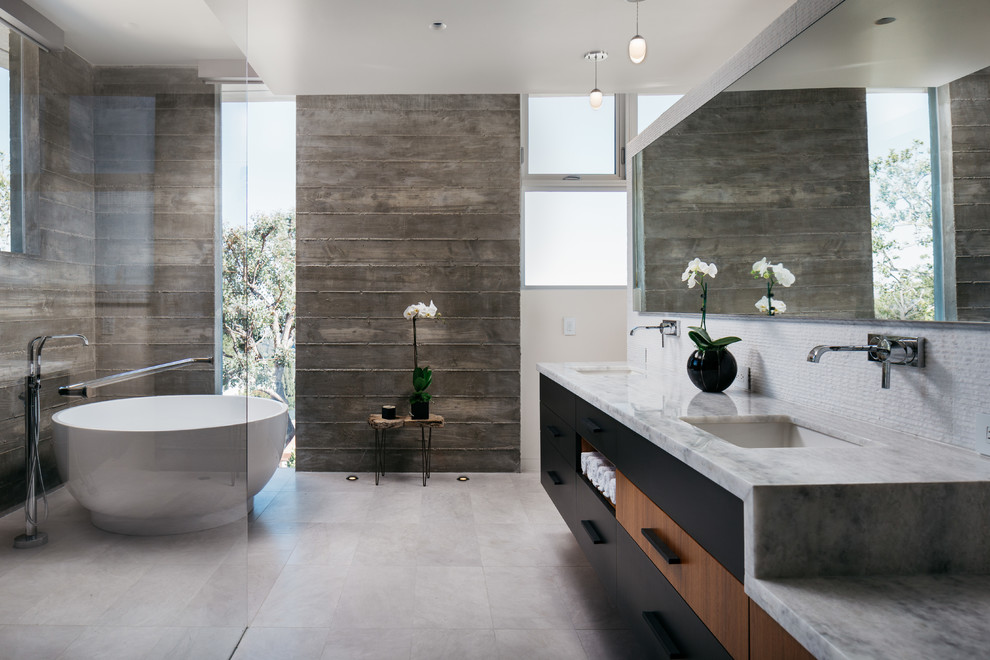 Contemporary master wet room bathroom in Orange County with flat-panel cabinets, black cabinets, a freestanding tub, gray tile, grey walls, an undermount sink, grey floor and grey benchtops.